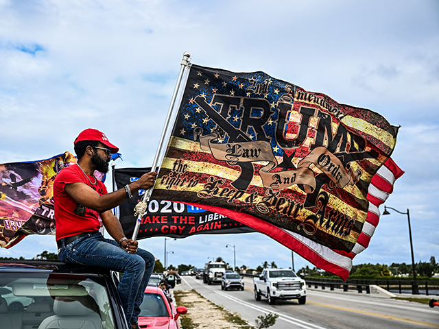 A supporter of former US President Donald Trump holds a flag near Mar-a-Lago Club in Palm Beach, Florida, on March 20, 2023. - Former US President Donald Trump said he expects to be "arrested" on Tuesday, March 21, 2023, over an alleged hush-money payment to a porn star in 2016 …