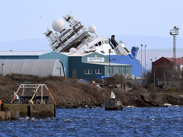Emergency teams attend the scene after a ship, the research vessel the 'Petrel', tipped over at a 45-degree angle in the Imperial Dock area in Leith, Scotland on March 22, 2023. The Scottish Ambulance Service said 15 people had been taken to hospital and 10 people were treated at the …