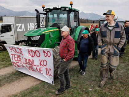 KRANJ, SLOVENIA - 2023/03/24: Farmers walk by a tractor with a sign that says 'Who will love you, field, when farmers are gone' during an agricultural reform protest in Kranj. Farmers gathered to protest against the government's planned agricultural reforms in Slovenia. (Photo by Luka Dakskobler/SOPA Images/LightRocket via Getty Images)