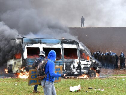 A French gendarme vehicle burns during clashes as part of a demonstration called by the co