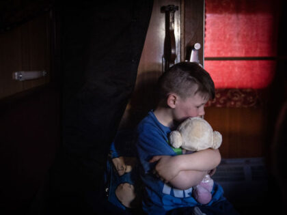 ZAPORIZHZHIA, UKRAINE - MARCH 26: An orphan boy hugs a soft toy as he waits on a train after fleeing the town of Polohy which has come under Russian control before evacuating on a train from Zaporizhzhia to western Ukraine on March 26, 2022 in Zaporizhzhia, Ukraine. Tens of thousands …