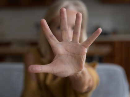 Close up focus unrecognizable older female show palm to cam, stretched her hand to camera makes stop gesture, say no, opposes age or gender discrimination, against domestic violence, protest concept