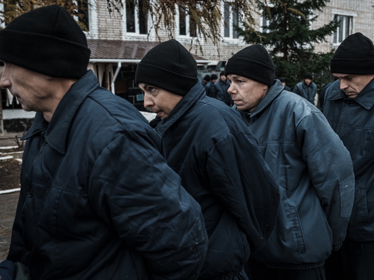 WESTERN UKRAINE - DECEMBER 2: Russian prisoners of war walk in a line through the territory of a prison on December 2, 2022 in Western Ukraine. Russian military personnel who were captured in Ukrainian territory are taken care of by the Coordination Headquarters for the Treatment of Prisoners of War. Thus, in the camp for Russian prisoners of war in the west of Ukraine, all the necessary conditions of stay in accordance with international conventions have been created - three meals a day, the opportunity to visit the church, an equipped bomb shelter, a medical block with a dental and X-ray room, a shower, a recreation room, a TV and the ability to call relatives via the Internet. Prisoners of war are involved in simple productions - gluing gift packages or chopping wood chips for kindling, for which they receive money in accordance with the Geneva Convention. (Photo by Serhii Mykhalchuk/Global Images Ukraine via Getty Images)