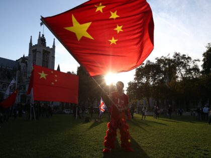 LONDON, ENGLAND - OCTOBER 20: A pro-China activist waves a Chinese flag as he demonstrates near Parliament ahead of a visit by China's President, Xi Jinping on October 20, 2015 in London, England. The President of the People's Republic of China, Mr Xi Jinping and his wife, Madame Peng Liyuan, …