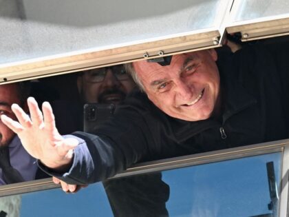 TOPSHOT - Former Brazilian president Jair Bolsonaro greets supporters from a window at the
