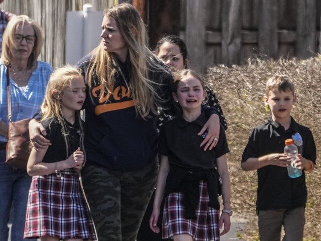 Children and a woman depart the reunification center at the Woodmont Baptist church after a school shooting, Monday, March 27, 2023, in Nashville, Tennessee. (John Bazemore/AP)