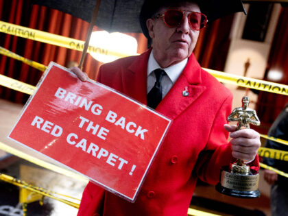 A person carries a sign reading Bring Back the Red Carpet as preparations are made ahead of the 95th Academy Awards, in Hollywood, California, on March 11, 2023. - The red carpet for the Oscars airing on March 12, 2023, is champagne-color for 2023. (Photo by Stefani Reynolds / AFP) …