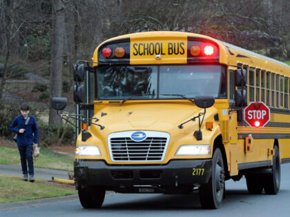 FILE -A Cobb County School bus moves on street Friday, March 13, 2020, in Kennesaw, Ga. Ge