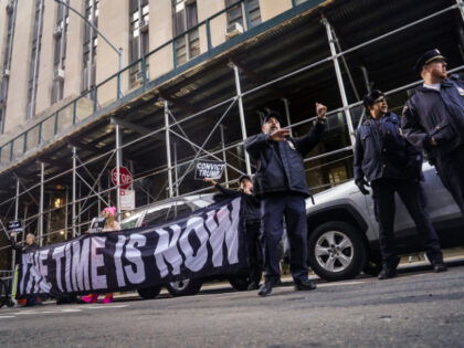 Demonstrators unveil a banner outside Manhattan's district attorney office, supportin