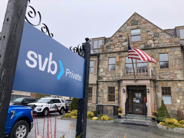 Vehicles are parked outside a Silicon Valley Bank branch in Wellesley, Mass., on Saturday,