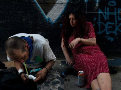 Jenn Bennett, who is high on fentanyl, sits on her skateboard with a visible black eye as her friend, Jesse Williams, smokes the drug in Los Angeles, Tuesday, Aug. 9, 2022. Use of fentanyl, a powerful synthetic opioid that is cheap to produce and is often sold as is or …
