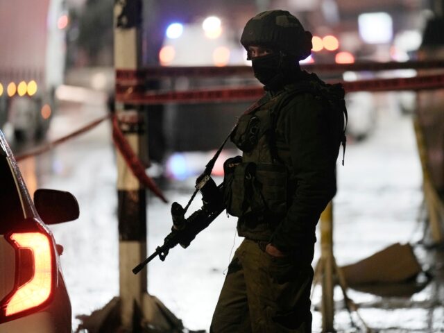An Israeli soldier works at the scene where officials say a Palestinian gunman opened fire