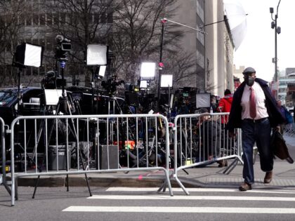 NEW YORK, NEW YORK - MARCH 22: People walk by journalists reporting outside of the Criminal Courts Building as the grand jury continues to hear evidence against former President Donald Trump on March 22, 2023 in New York City. The grand jury is meeting to decide if Trump should be …