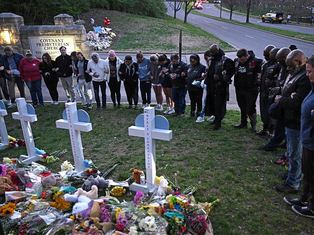 TOPSHOT - Members of the Selected First Motorcycle Club join others in prayer at a makeshift memorial for victims of a shooting at the Covenant School campus, in Nashville, Tennessee, March 28, 2023. - A heavily armed former student killed three young children and three staff in what appeared to be a carefully planned attack at a private elementary school in Nashville on March 27, 2023, before being shot dead by police. Chief of Police John Drake named the suspect as Audrey Hale, 28, who the officer later said identified as transgender. (Photo by Brendan SMIALOWSKI / AFP) (Photo by BRENDAN SMIALOWSKI/AFP via Getty Images)