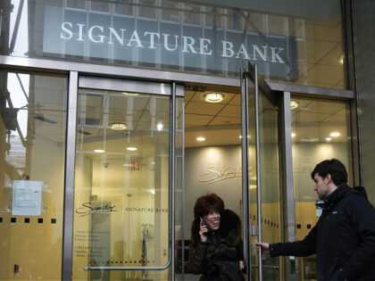 A woman leaves a branch of Signature Bank in New York, Monday, March 13, 2023. President Joe Biden is telling Americans that the nation's financial systems are sound. This comes after the swift and stunning collapse of two banks that prompted fears of a broader upheaval. (AP Photo/Seth Wenig)
