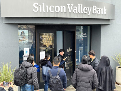 A worker (center) tells people that the Silicon Valley Bank (SVB) headquarters is closed o