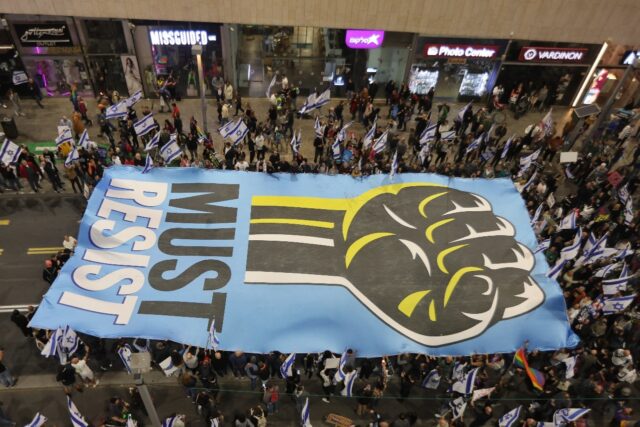 Israelis in Tel Aviv carry a sign during their latest weekly protest against the governmen