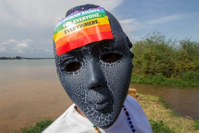 A Ugandan wearing a mask with a rainbow sticker takes part in a Gay Pride parade in Entebbe in 2015