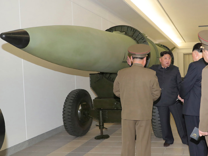 This photo provided on Tuesday, March 28, 2023, by the North Korean government, North Korean leader Kim Jong Un, rear, talks with military officials at a hall displayed what appeared to be various types of warheads designed to be mounted on missiles or rocket launchers on March 27, 2023, in …