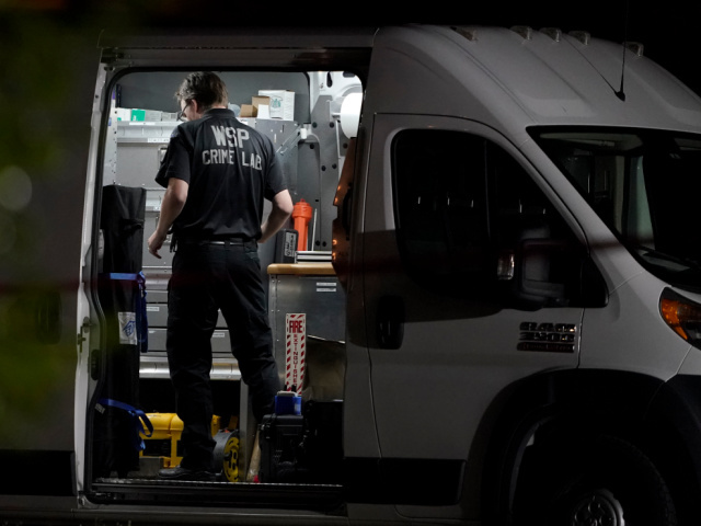 A Washington State Patrol Crime Lab worker stands in a van, Thursday, Sept. 3, 2020, in La