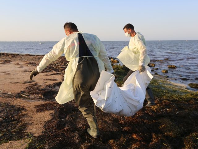 TOPSHOT - Tunisian civil protection workers recover the body of an African migrant near th