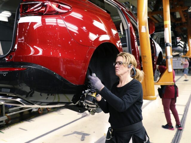 An employee installs components on a vehicle at the General Motors Co. Lansing Delta Towns