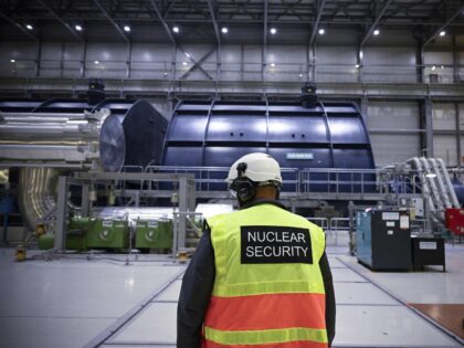 A security agent inspects the turbine room linked to the OL3, the latest among three reactors at the nuclear power plant Olkiluoto on the island of Eurajoki, western Finland, on October 5, 2022. - Finland's long-delayed Olkiluoto 3 nuclear reactor has reached full power to become the most powerful electricity …