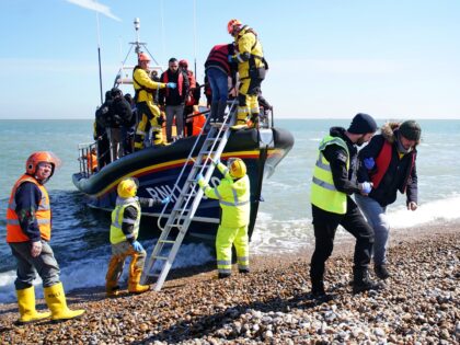 A group of people thought to be migrants arrive on the beach in Dungeness, Kent, after being rescued by the RNLI Life Boat following a small boat incident in the Channel. Picture date: Tuesday April 4, 2023. (Photo by Gareth Fuller/PA Images via Getty Images)