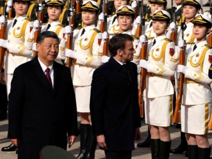 China's President Xi Jinping (L) and his French counterpart Emmanuel Macron review a