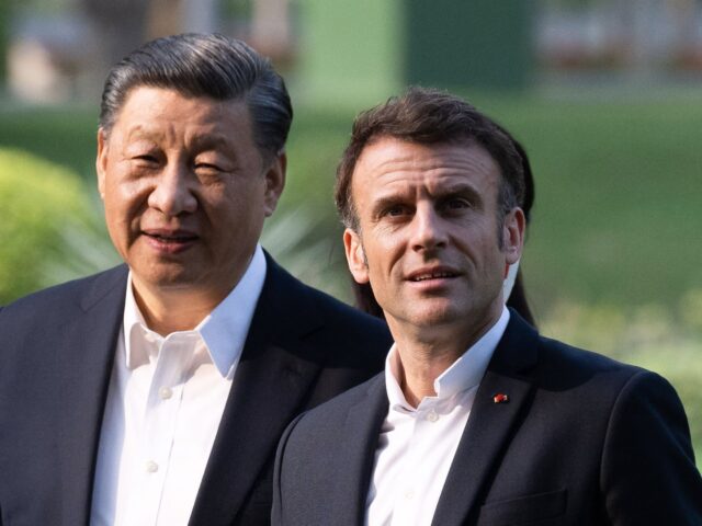 TOPSHOT - Chinese President Xi Jinping (L) and French President Emmanuel Macron (R) visit the garden of the residence of the Governor of Guangdong, on April 7, 2023, where Chinese President XI Jinping's father, XI Zhongxun lived. (Photo by Jacques WITT / POOL / AFP) (Photo by JACQUES WITT/POOL/AFP via …