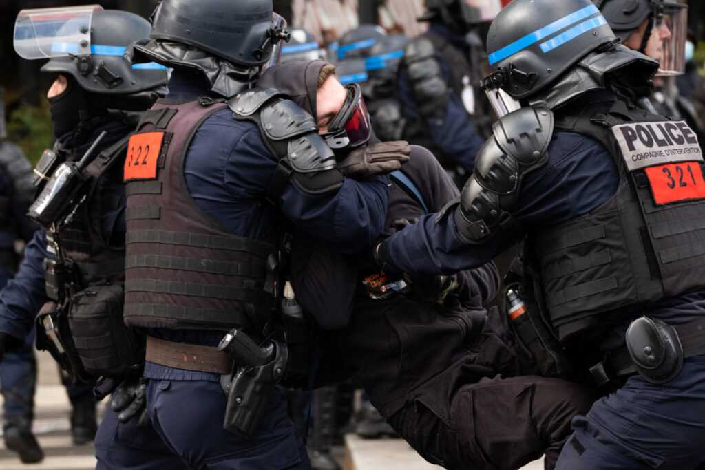 The riot police arrest a protester during a demonstration on the 12th day of action after the government pushed a pensions reform through parliament without a vote, using the article 49.3 of the constitution, in Paris on April 13, 2023. France faced nationwide protests and strikes on April 13, 2023, to denounce the French government's pension reform on the eve of a ruling from France's Constitutional Council on the reform. (Photo by Jerome Gilles/NurPhoto via Getty Images)