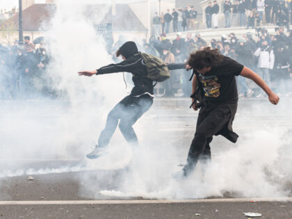 Demonstrators push back tear gas canisters fired by the police during a demonstration where for the twelfth time in three months, several thousand people, employees and students, demonstrated in the streets of Paris at the call of the interunion to protest against the pension reform proposed by the French government. …