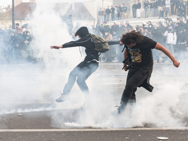 Demonstrators push back tear gas canisters fired by the police during a demonstration wher