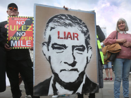 LONDON, ENGLAND - APRIL 15: A protester holding a sign with the Sadiq Khan's portrait with liar written across his forehead joins others against the ULEZ expansion at Trafalgar Square on April 15, 2023 in London, England. Protesters gather to voice their opposition to the extension of the Ultra Low …