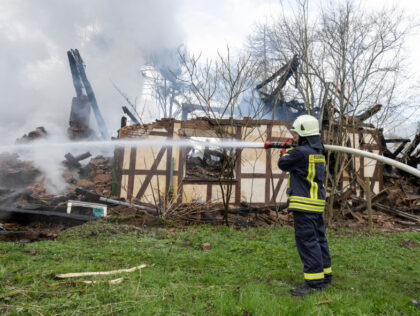 17 April 2023, Hesse, Wüstefeld: Firefighters extinguish the still smoking debris of the former farm of the "cannibal of Rotenburg", Armin M. The historic half-timbered house had caught fire during the night for as yet unexplained reasons and was completely destroyed. Photo: Boris Roessler/dpa (Photo by Boris Roessler/picture alliance via …