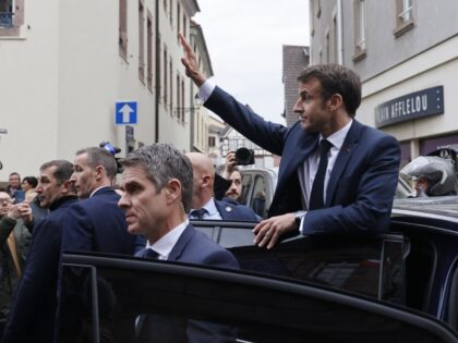 French President Emmanuel Macron waves to the crowd from his car as he leaves the city centre following a visit to Alsace on the theme of reindustrialisation, in Selestat, eastern France, on April 19, 2023. (Photo by LUDOVIC MARIN / POOL / AFP) (Photo by LUDOVIC MARIN/POOL/AFP via Getty Images)