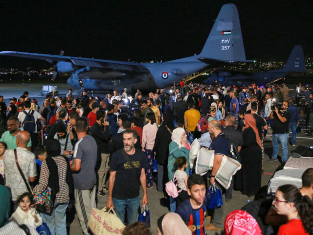 People evacuated from Sudan arrive at a military airport in Amman on April 24, 2023. - For