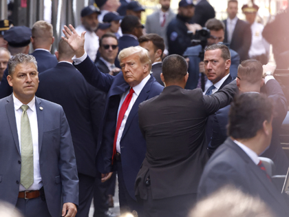 Former U.S. President Donald Trump waves as he arrives at the Manhattan Criminal Court on