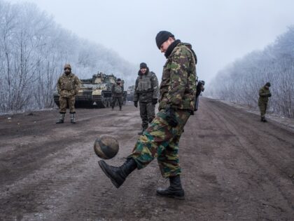 ARTEMIVSK, UKRAINE - FEBRUARY 15: Ukrainian soldiers play football on the road leading to the embattled town of Debaltseve on February 15, 2015 outside Artemivsk, Ukraine. A ceasefire scheduled to go into effect at midnight was reportedly observed along most of the front, save for near the embattled town of …