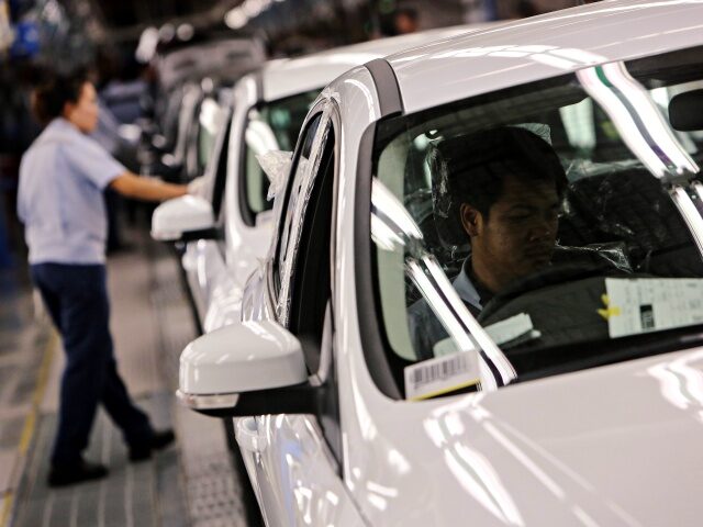 A worker inspects the interiors of a Ford Focus car at the quality control station at the