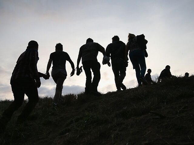 WESLACO, TX - APRIL 13: Undocumented immigrants are led after being caught and handcuffed