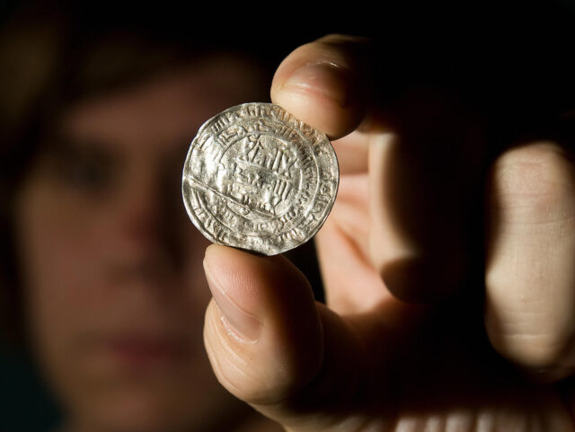 A siilver coin from the Vale of York viking hoard is displayed at a press conference to un