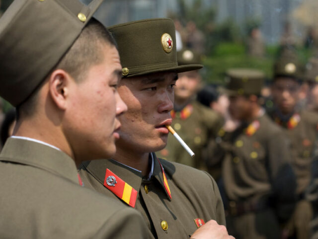 PYONGYANG, NORTH KOREA - APRIL 15: North Korean soldeirs smoking cigarettes in the street,