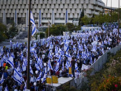Right-wing Israelis wave their national flag during a rally in support of plans by Prime Minister Benjamin Netanyahu's government to overhaul the judicial system, outside the Knesset, Israel's parliament in Jerusalem, Thursday, April 27, 2023. (AP Photo/Ohad Zwigenberg)