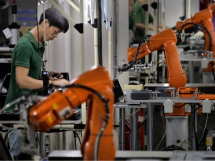 FILE - In this Aug. 21, 2015 file photo, a man works amid orange robot arms at Rapoo Technology factory in southern Chinese industrial boomtown of Shenzhen. China issued an outline Friday, Nov. 15, 2019, of policies aimed at promoting high-tech manufacturing after it stopped pushing a strategy that helped …