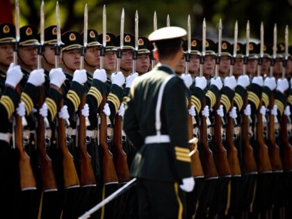 A Chinese People's Liberation Army soldier watches the position of members of a guard of honor as they prepare for a welcome ceremony for visiting Indian Prime Minister Manmohan Singh, outside the Great Hall of the People in Beijing Wednesday, Oct. 23, 2013. China and India signed a confidence-building accord …