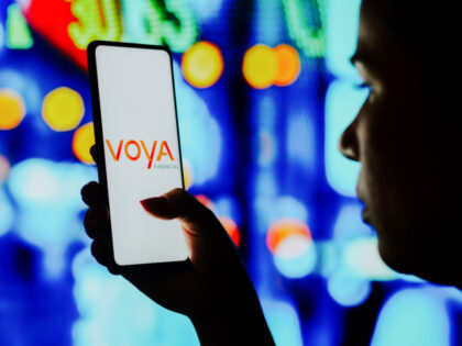 In this photo illustration, a silhouetted woman holds a smartphone with the Voya Financial logo displayed on the screen. (Photo Illustration by Rafael Henrique/SOPA Images/LightRocket via Getty Images)