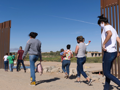 A group of Brazilian migrants make their way around a gap in the U.S.-Mexico border in Yum