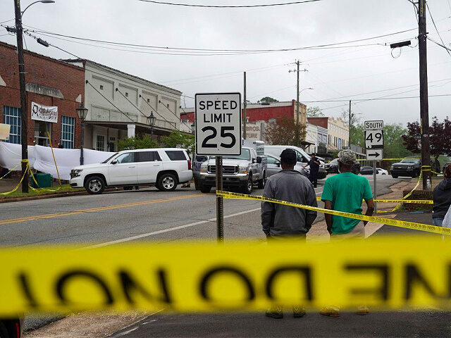 DADEVILLE, AL - APRIL 16: Community members watch as crime scene investigators work the sc