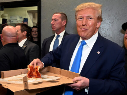 Former President Donald Trump receives his order at Downtown House of Pizza after speaking at the Lee County Republican dinner in Fort Myers, Fla., Friday, April 21, 2023. (AP Photo/Chris Tilley